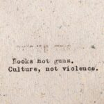 Typewritten message promoting peace over violence on rough paper.