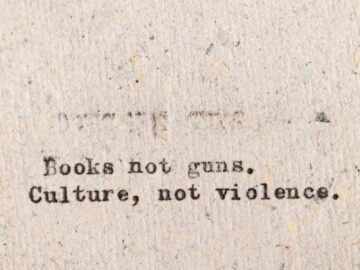 Typewritten message promoting peace over violence on rough paper.