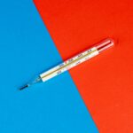 Glass thermometer on a vibrant red and blue background, symbolizing health and temperature measurement.