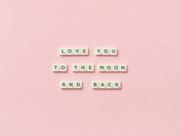 Letter tiles spelling 'Love You to the Moon and Back' on a pink background.