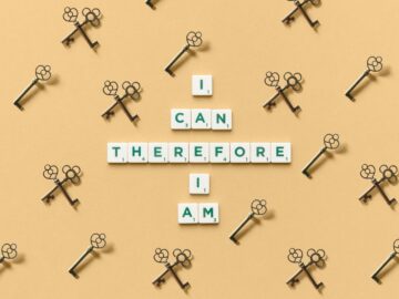 Inspirational phrase made from tiles surrounded by decorative keys on a beige background.