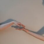 Close-up of two hands reaching towards each other, symbolizing connection.