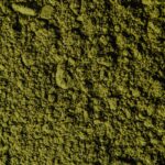 Closeup view of coarse green matcha powder texture, ideal for backgrounds and culinary themes.