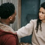 A diverse couple engages in a tense confrontation on an urban street.