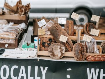 Different delicious fresh breads and loaves placed on wooden trays in small street bakery