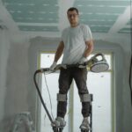 A construction worker using stilts for ceiling renovation indoors, enhancing space with expertise.