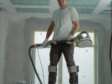 A construction worker using stilts for ceiling renovation indoors, enhancing space with expertise.