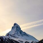 Captivating snowy peak of the Matterhorn in winter, with blue sky and scattered clouds.