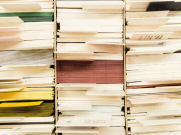 Close-up view of stacked documents in various colors organized in a file system.
