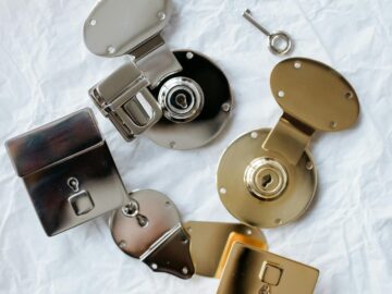 Detailed flat lay of different colored metallic locks and a key on a textured background.
