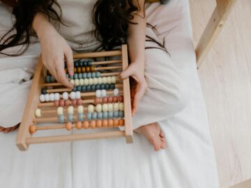 A child using a colorful abacus to learn math in a cozy indoor setting.