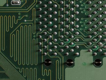 Detailed close-up of electronic circuit board with intricate green patterns and components.