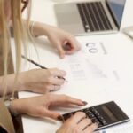 Team working with a calculator and reports on a professional desk.