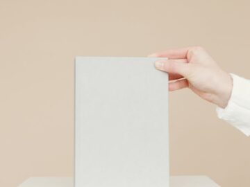 Simple minimalist image of a blank book being held by a person's hand, ideal for branding.