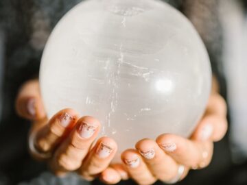 Close-up of hands holding a clear crystal ball, ideal for spiritual or metaphysical themes.