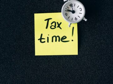 A clock on a sticky note with 'Tax time!' emphasizes importance of tax deadlines.
