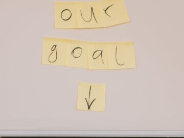 Sticky notes on wall with 'Our Goal' text for office motivation.