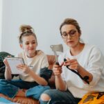 Mom and daughter bonding over learning tools on the couch indoors.