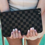 person holding Damier Graphite Louis Vuitton bag
