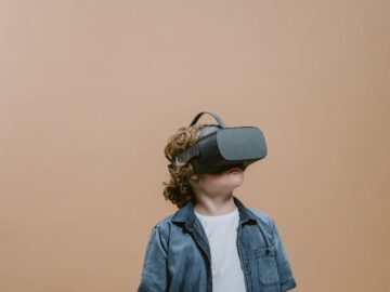 Young boy wearing VR headset, immersed in virtual reality experience indoors.