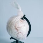 A globe wrapped in plastic highlights the pressing issue of global pollution and environmental conservation.