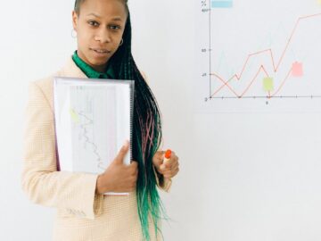Confident analyst presenting financial data and growth charts in a modern office setting.