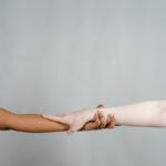 Two hands of different skin tones joining, symbolizing diversity and unity.