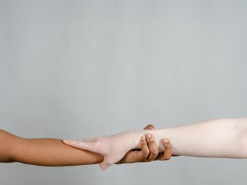 Two hands of different skin tones joining, symbolizing diversity and unity.