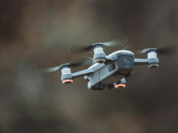 A detailed close-up of a drone flying in an outdoor setting, showcasing its design and technology.