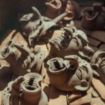 A collection of handmade clay masks drying in an oven, showcasing creativity and craftsmanship.