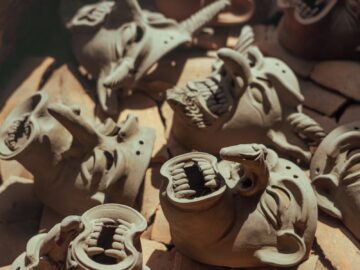 A collection of handmade clay masks drying in an oven, showcasing creativity and craftsmanship.