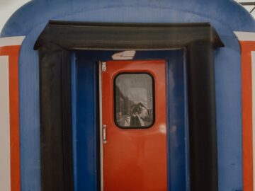 Close-up of a colorful train door, showcasing vibrant blue and red tones.