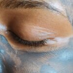Closeup crop face of ethnic woman with closed eyes and clay mask applied on skin