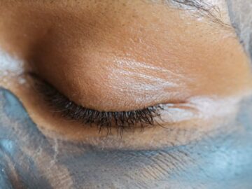 Closeup crop face of ethnic woman with closed eyes and clay mask applied on skin