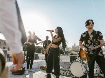 A diverse band performs outdoors at sunset, showcasing various musical instruments and talent.