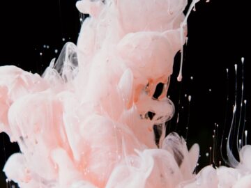 Stunning capture of pink ink swirling in water, creating an artistic and fluid abstract design.