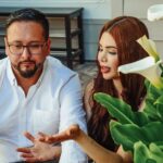 A couple sitting together outdoors, receiving keys, symbolizing a new beginning.