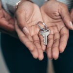 Close-up of hands holding a key, symbolizing homeownership, real estate, and property investment.