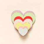A collection of colorful heart-shaped paper cutouts stacked in a layered design.