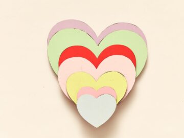 A collection of colorful heart-shaped paper cutouts stacked in a layered design.