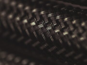Detailed close-up of a dark, braided metal wire texture showcasing intricate patterns.