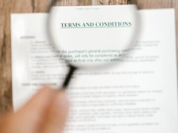 Magnifying glass focusing on 'Terms and Conditions' in a document. Ideal for business and legal themes.
