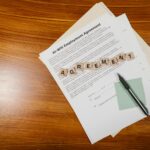 A flat lay of an employment agreement with Scrabble tiles on a wooden table.
