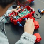 A child actively assembling a robotics project with electronic components, showcasing technology education.