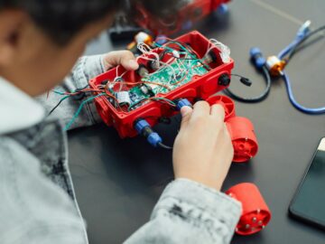A child actively assembling a robotics project with electronic components, showcasing technology education.