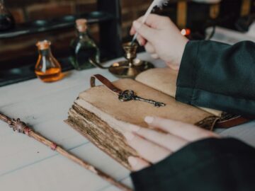 Mystical setup with a quill, spell book, and magical potions.