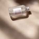 A minimalist clear cosmetic bottle casting soft shadows, perfect for skincare and beauty promotions.