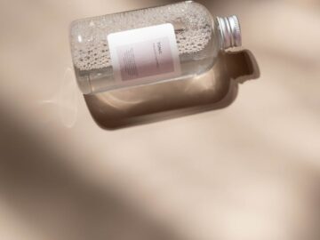 A minimalist clear cosmetic bottle casting soft shadows, perfect for skincare and beauty promotions.