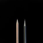 A clean, minimalist shot showcasing a traditional pencil and a mechanical pencil against a black background.