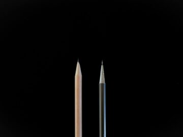 A clean, minimalist shot showcasing a traditional pencil and a mechanical pencil against a black background.